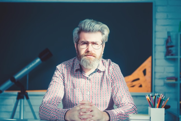 Retrato de homem sênior antiquado sorridente com barba grisalha e óculos