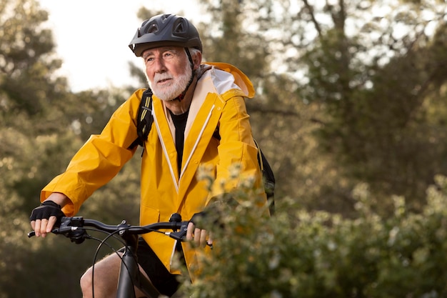 Foto retrato de homem sênior com bicicleta na montanha