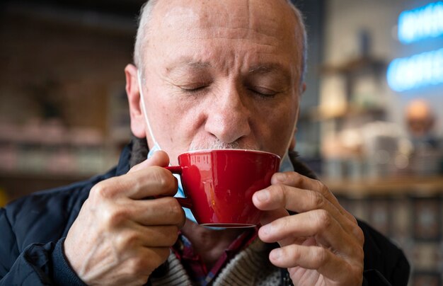 Retrato de homem sênior desfrutando de uma xícara de café no café