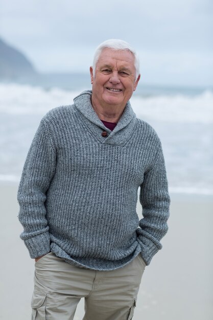 Retrato de homem sênior em pé na praia