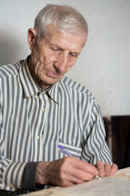 Retrato de homem sênior escrevendo em um caderno