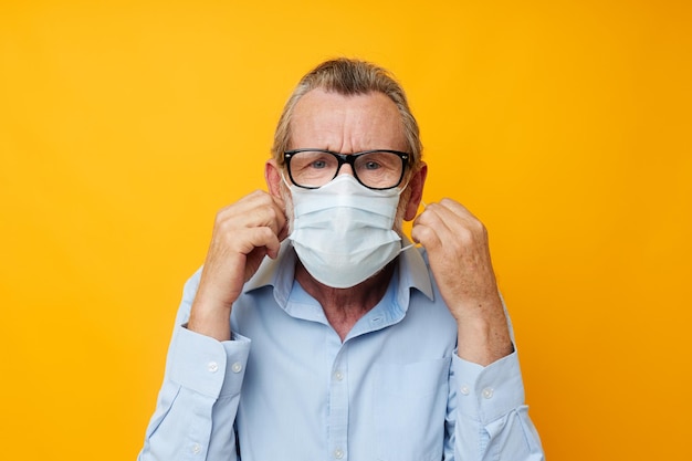 Retrato de homem sênior feliz com máscara médica de segurança de óculos posando vista cortada