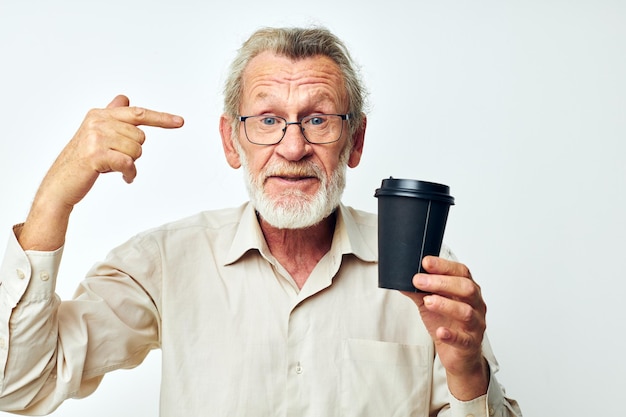 Retrato de homem sênior feliz com uma barba grisalha em uma camisa e óculos de fundo claro