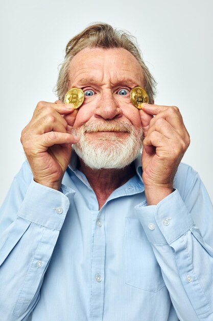 Retrato de homem sênior feliz em uma camisa azul bitcoins na vista cortada do rosto