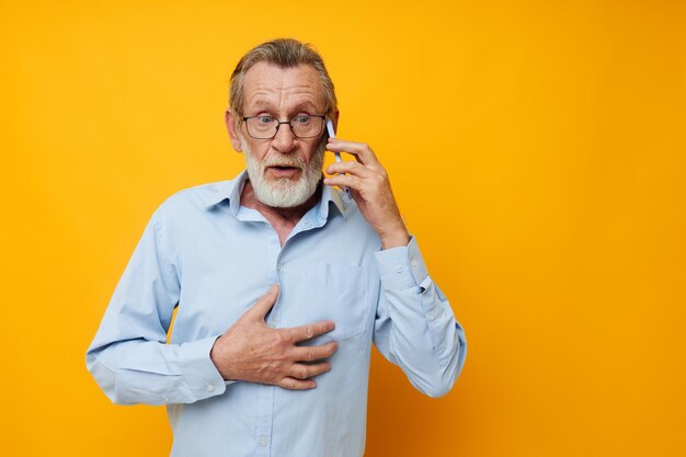 Retrato de homem sênior feliz falando ao telefone fundo isolado de emoções