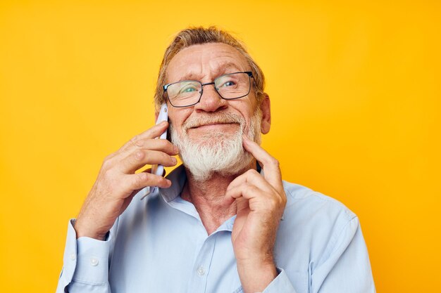 Retrato de homem sênior feliz falando ao telefone fundo isolado de emoções