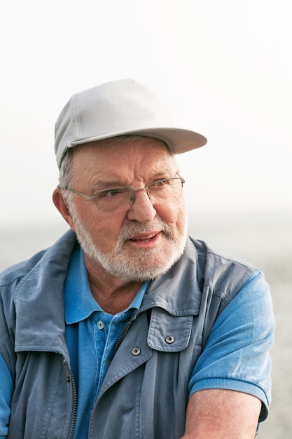 Retrato de homem sênior feliz sorridente ao ar livre olhando para longe