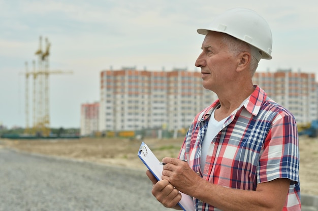 Retrato de homem sênior no canteiro de obras