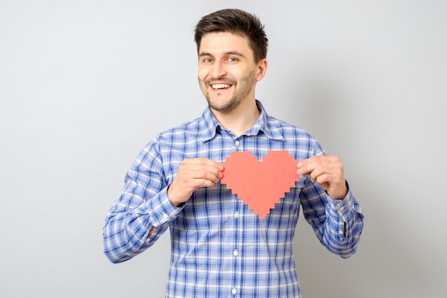 Retrato de homem sorridente segurando coração de pixel de papel vermelho