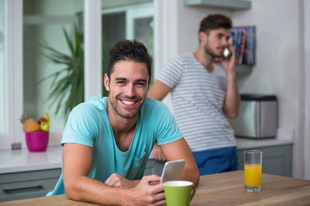 Retrato de homem usando o telefone na mesa