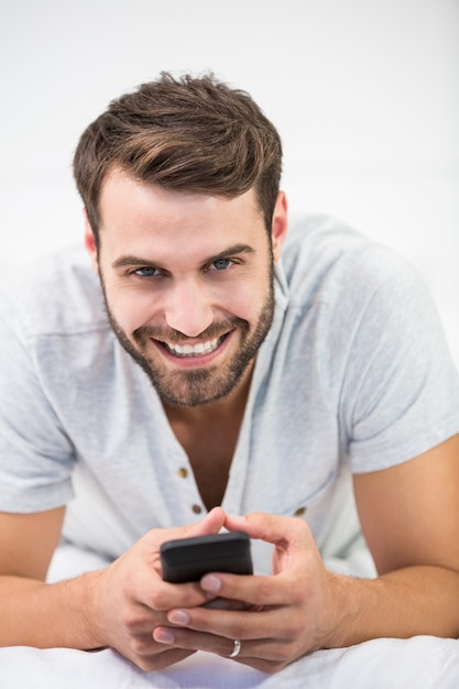 Retrato, de, homem, usando telefone móvel, cama