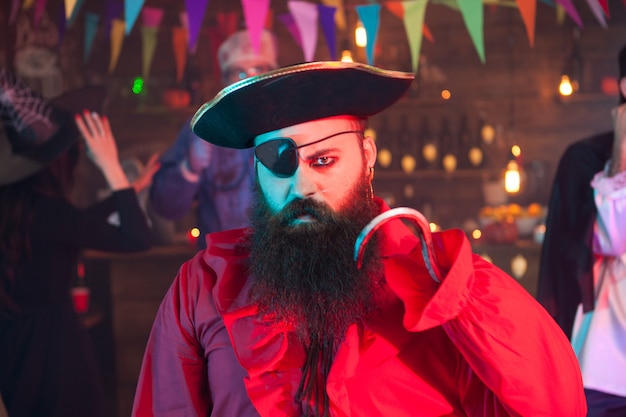 Retrato de homem vestido de pirata, olhando com raiva para a câmera enquanto celebra o dia das bruxas. Fantasia de Dia das Bruxas.