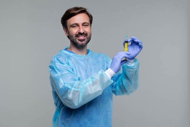 Retrato de homem vestindo bata médica e segurando a seringa