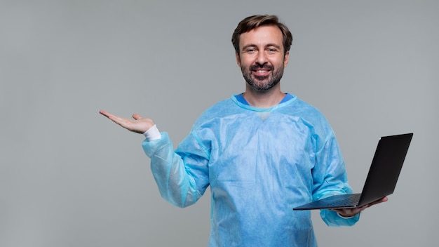 Foto retrato de homem vestindo bata médica e segurando laptop