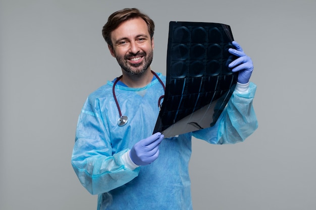 Foto retrato de homem vestindo bata médica e segurando o raio-x