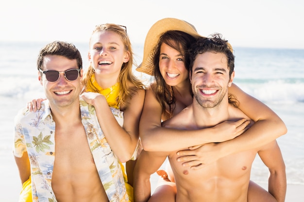 Retrato de homens dando um cavalinho para mulheres na praia