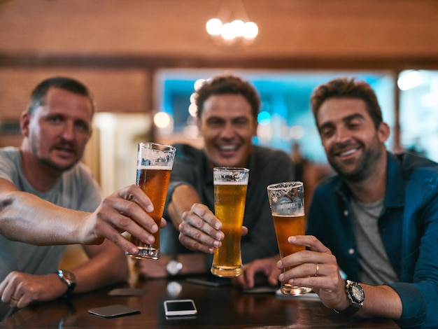 Retrato de homens e cerveja em um pub com copos como celebração para bebidas felicidade ou vínculo social Amigos aplaude e pessoas no restaurante para evento de festa de aniversário e reunião na Alemanha com brinde