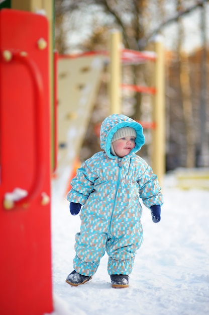 Retrato de Inverno de menino bonito da criança no parque infantil