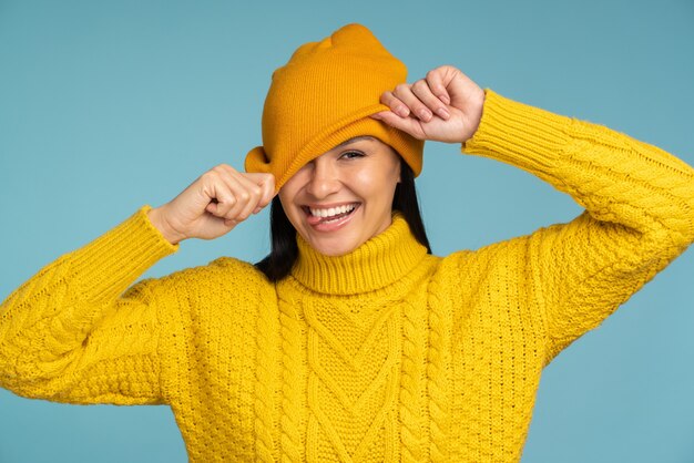 Retrato de inverno de mulher bonita. Mulher sorridente, vestindo roupas quentes, se divertindo com o chapéu e mostrando caretas engraçadas