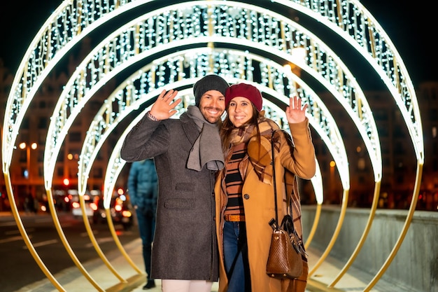 Retrato de inverno de um casal caucasiano apreciando as luzes de Natal