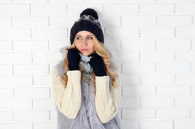 Retrato de inverno de uma jovem loira bonita em suas roupas quentes de tricô