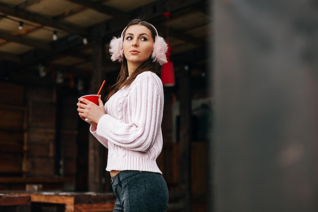 Retrato de inverno de uma linda mulher segurando um café para sair no inverno