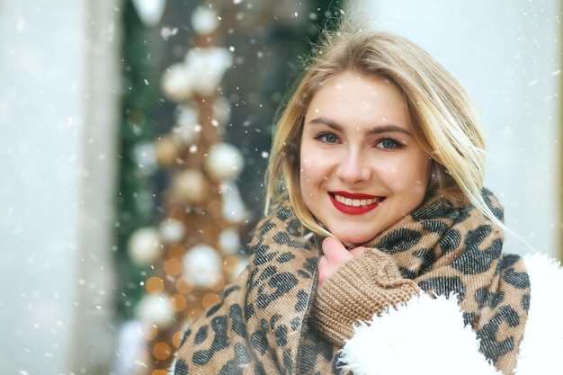 Retrato de inverno de uma mulher alegre, andando na cidade com flocos de neve. Espaço vazio