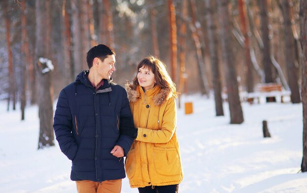 Retrato de inverno quente de um casal de raça diferente na floresta.