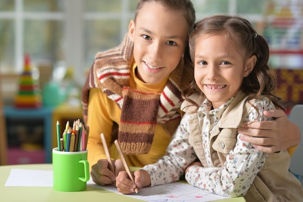 Retrato de irmão e irmã sorridentes desenhando juntos