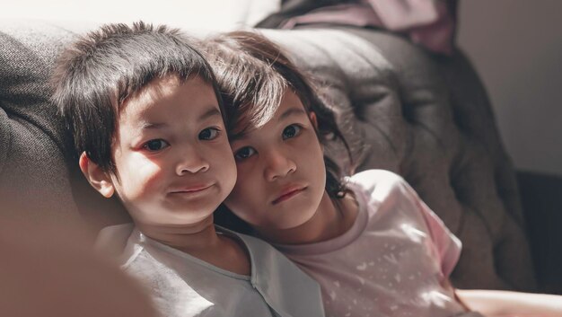 Foto retrato de irmãos bonitos relaxando no sofá em casa