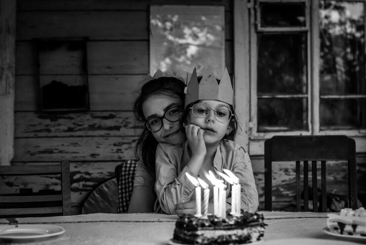 Foto retrato de irmãos na mesa contra o bolo de aniversário