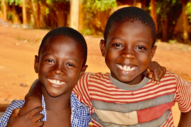 Foto retrato de irmãos sorridente de pé ao ar livre