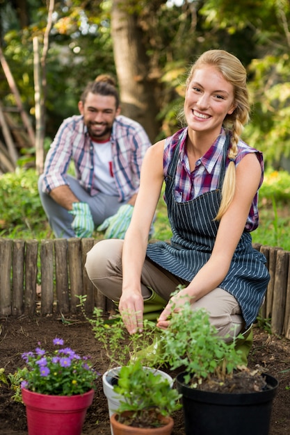 Retrato de jardineiro feliz com colega plantando no jardim