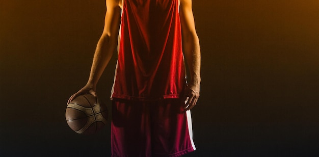 Retrato de jogador de basquete segurando uma bola em uma academia