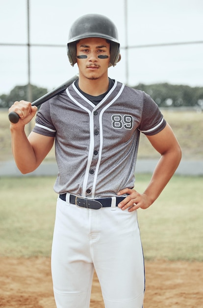 Retrato de jogador de beisebol olhando focado com tinta no rosto Atleta ativo sério e em forma usando um capacete durante um jogo em um campo Homem desportivo segurando um taco antes de jogar uma partida