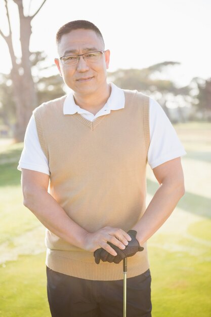 Retrato de jogador de golfe posando com seu taco de golfe