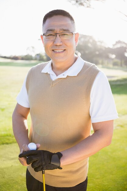 Retrato de jogador de golfe posando com uma bola