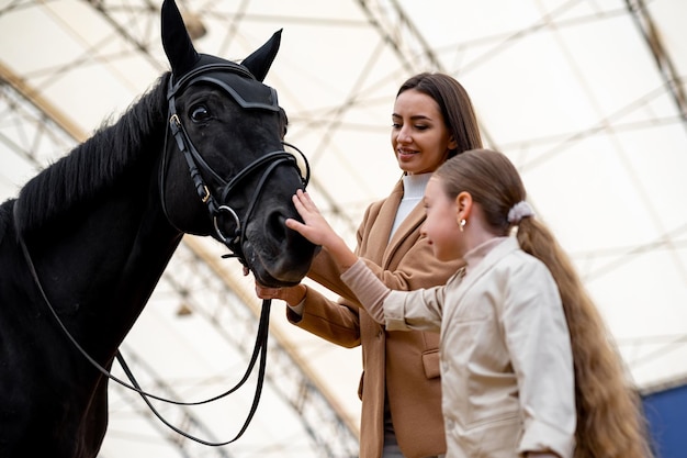 Retrato de jóquei feminino com cavalo Moça bonita com cavalo