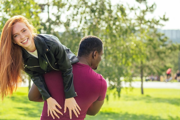 Retrato de jovem abraçando sua namorada juntos em um parque primavera verão em um dia ensolarado.