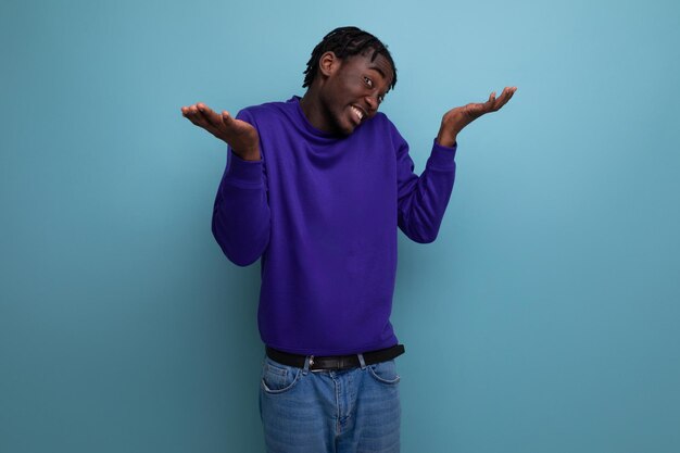 Retrato de jovem adulto afro-americano frustrado em jeans isolado em fundo liso