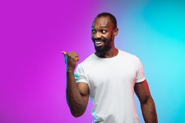 Retrato de jovem afro-americano em fundo gradiente de estúdio em néon