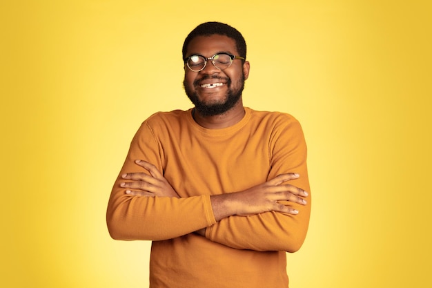 Retrato de jovem afro-americano isolado na expressão facial amarela.
