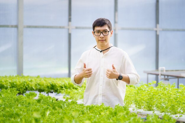 Retrato de jovem agricultor inteligente usando computador tablet digital para inspeção. usando tecnologia na aplicação de campo de agricultura na atividade de cultivo agrícola e verificando o conceito de qualidade.