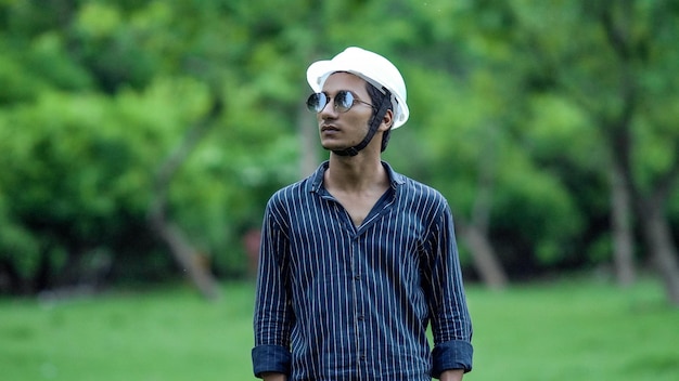 Retrato de jovem alegre usando capacete no lado da fazenda