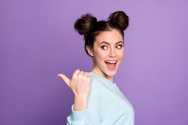 Retrato de jovem animado e positivo apontar o polegar copyspace indica vendas incríveis, sugerir selecione usar roupas da moda isoladas sobre fundo de cor violeta