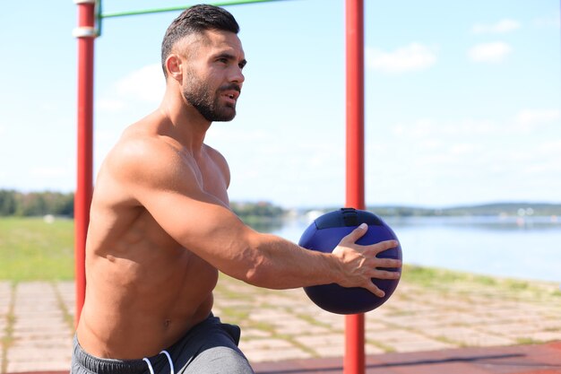 Retrato de jovem apto e desportivo, fazendo alongamento ao ar livre.