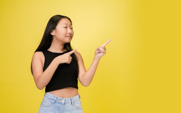 Retrato de jovem asiática isolada em amarelo