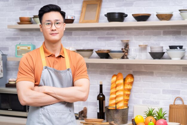 Retrato de jovem asiático na cozinha