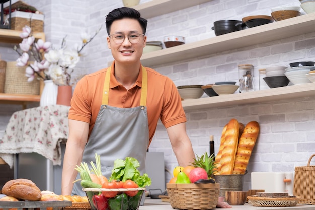 Retrato de jovem asiático na cozinha