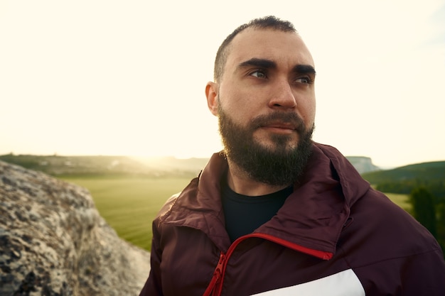 Retrato de jovem barbudo ao ar livre nas montanhas